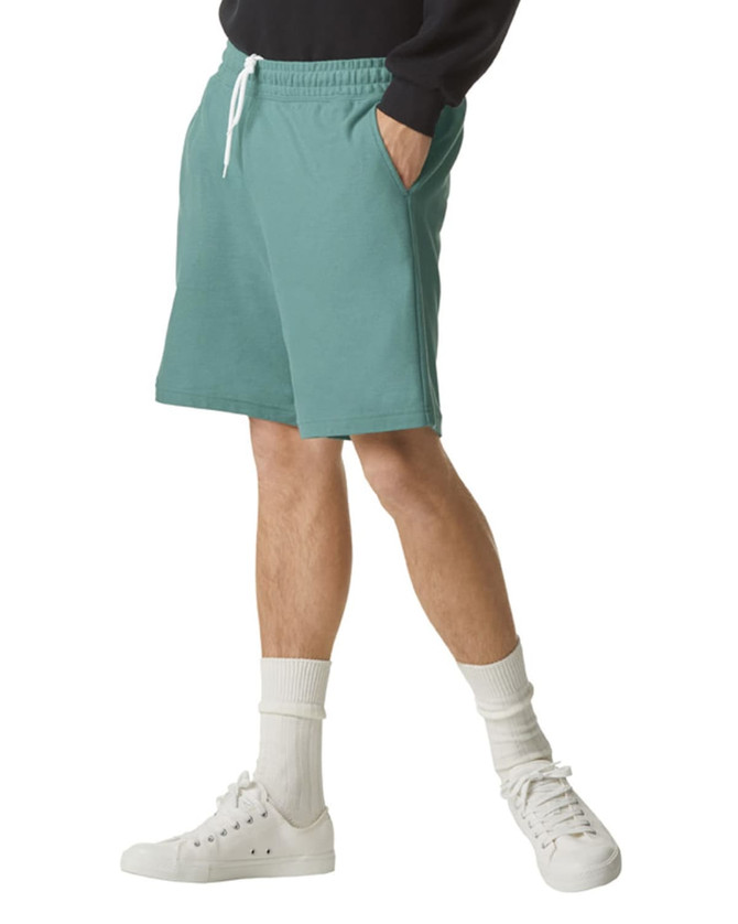 Unisex sports shorts in teal, featuring an elastic waistband, side pockets, and a simple logo.
