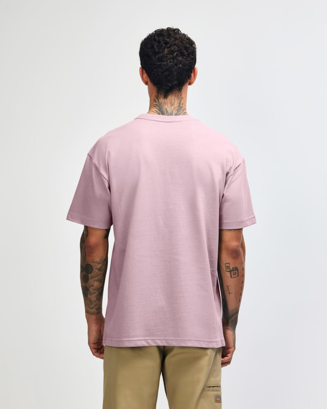 A person facing away wears a purple American Apparel Super Heavyweight T-Shirt, showing its back. The shirt has a subtle brand logo.