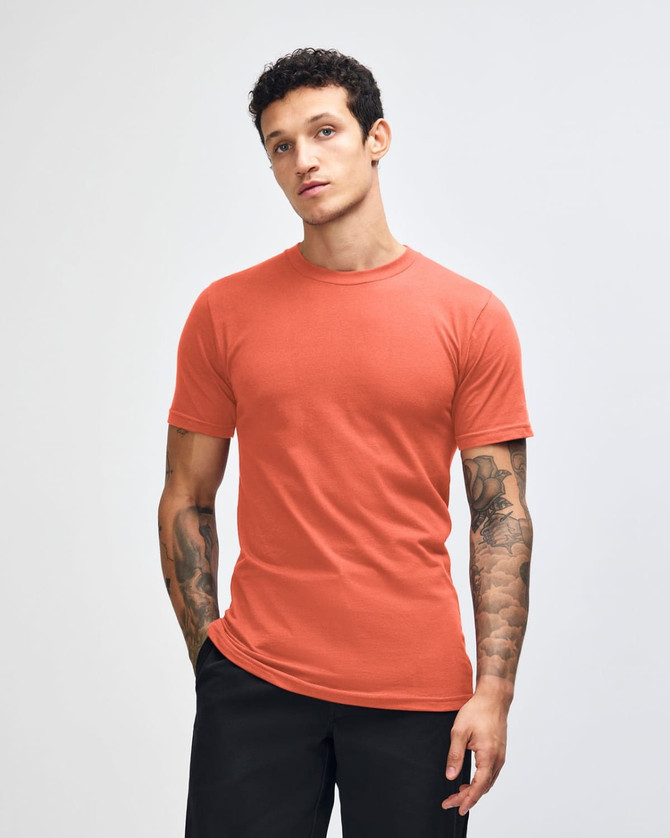 An orange unisex short sleeve t-shirt displayed on a model with long hair, featuring a logo.