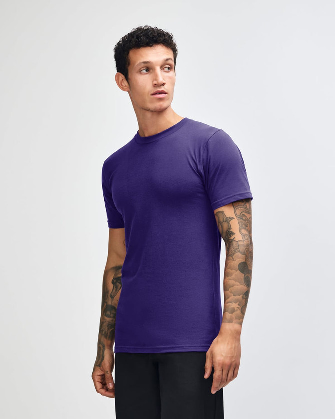 A purple unisex short sleeve T-shirt displayed on a model, featuring a logo on the chest.