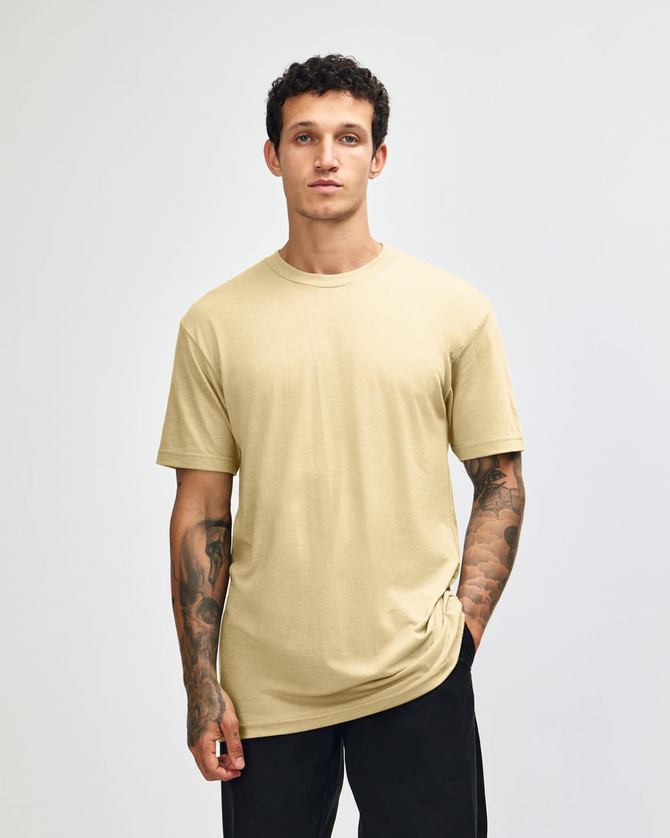 A unisex short sleeve t-shirt in a pale yellow colour, displayed on a model against a plain background.