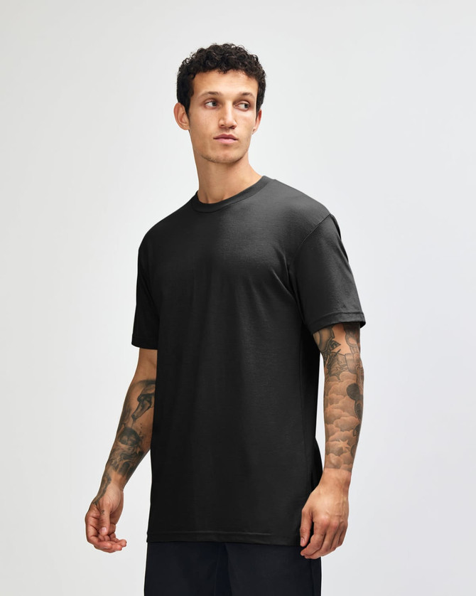 A black unisex CVC short sleeve t-shirt displayed on a model, featuring a simple design and a logo.