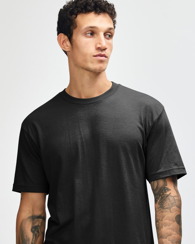 A black unisex short sleeve T-shirt worn by a model, showcasing a simple, classic design.