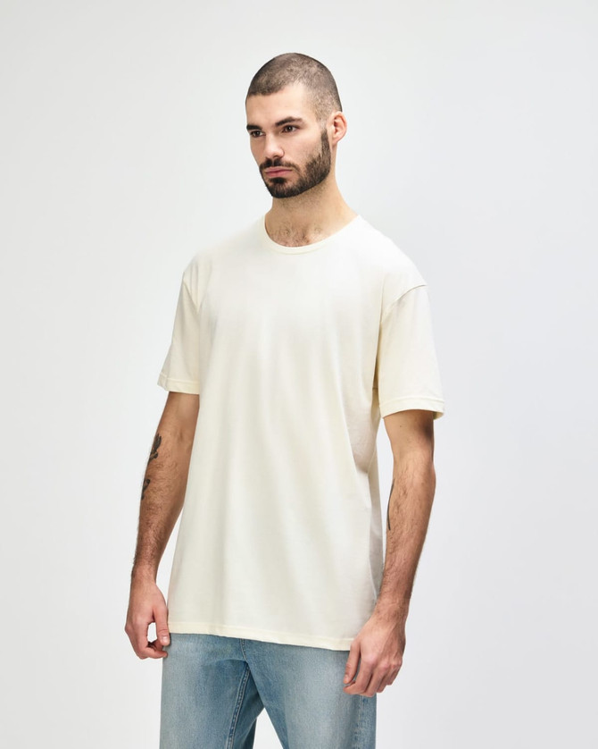 A white Gildan Softstyle adult T-shirt displayed on a model, paired with casual blue jeans.