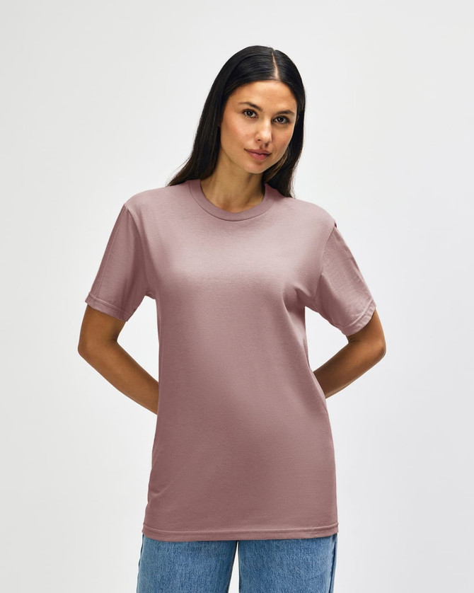 A model wearing a Gildan Softstyle Adult Midweight T-Shirt in a muted pink colour with navy blue sides.