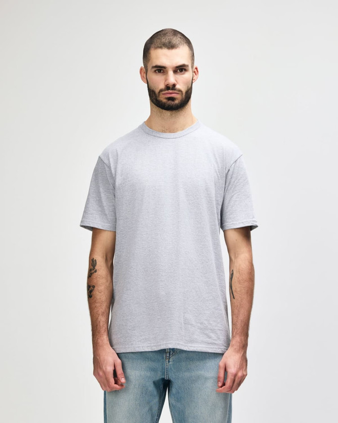 A grey Gildan Softstyle adult midweight T-shirt displayed on a male model, featuring a simple design and a logo.