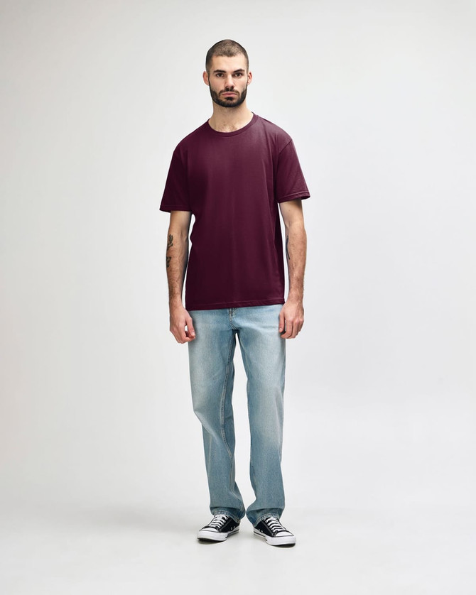 A maroon Gildan Softstyle adult midweight T-shirt displayed on a model, paired with black jeans and sneakers.