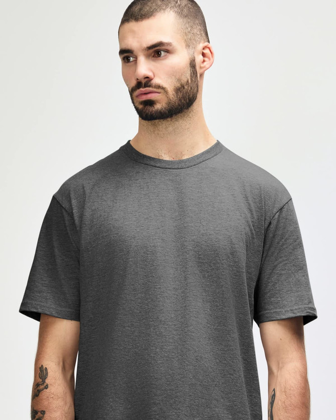 A grey midweight T-shirt featuring a crew neck and short sleeves, worn by a model with tattoos.