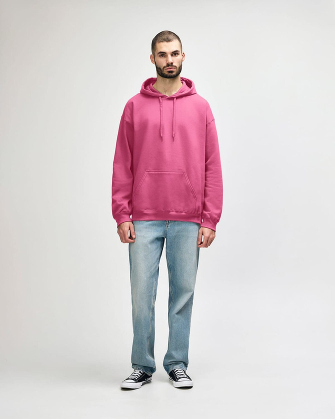 A pink hooded sweatshirt featuring a front pocket, paired with blue jeans and white sneakers.