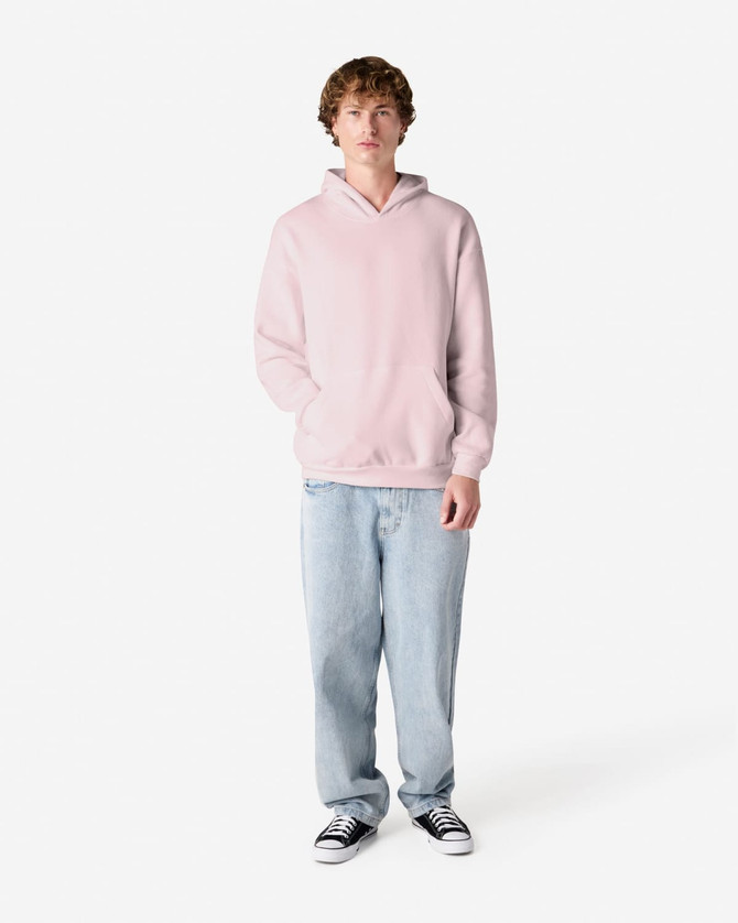 A unisex hooded sweatshirt in pink, featuring a front pocket and a logo, worn with light blue jeans.