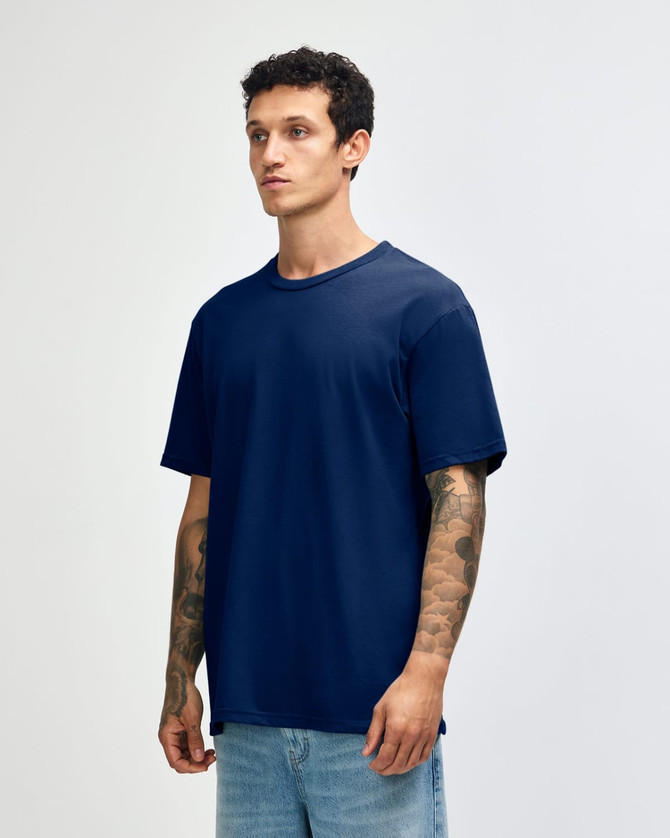A navy blue unisex short sleeve t-shirt on a model, featuring a relaxed fit and subtle branding.