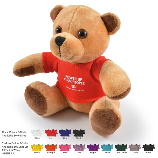 A fluffy tan teddy bear wearing a red T-shirt, sitting upright against a white background. Includes branding on the shirt.