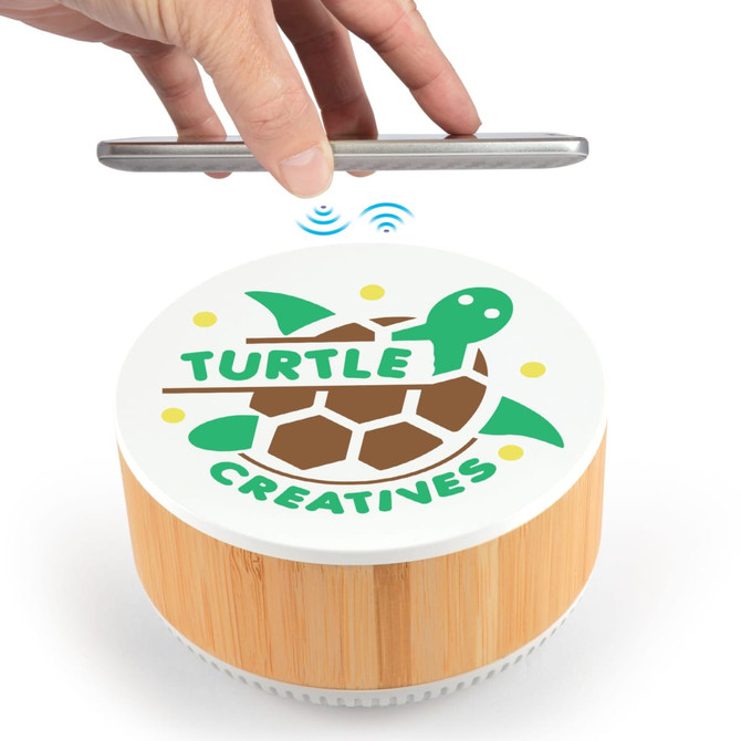 A wooden and white speaker with a turtle design on top, featuring wireless charging capabilities for smartphones.