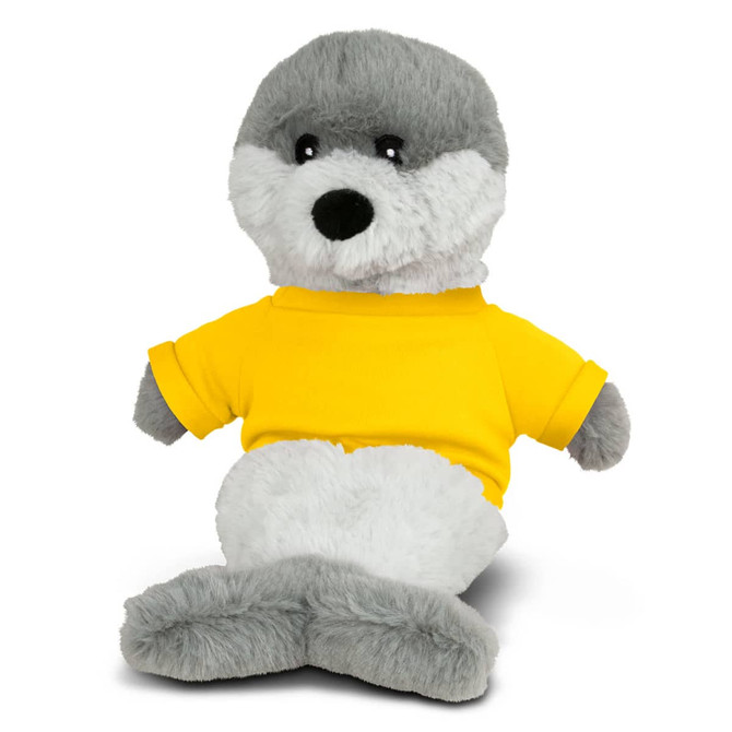A grey seal plush toy wearing a bright yellow shirt, sitting with a friendly expression. It has a soft, cuddly texture.