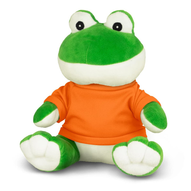 A green plush frog toy wearing an orange shirt, sitting with its legs extended and a friendly expression.