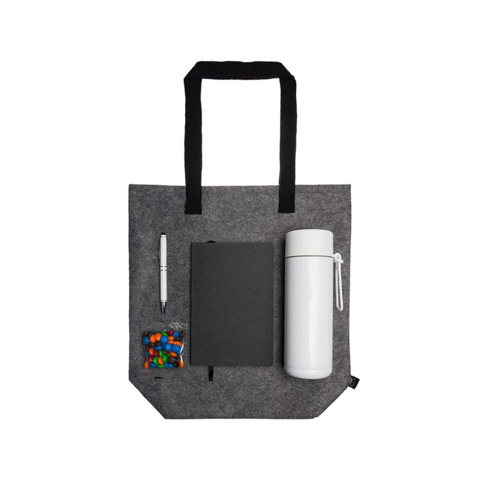 A gray tote bag containing a drink bottle, a notebook, a pen, and a small bag of candies.