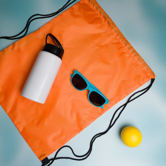 A drink bottle, a pair of turquoise sunglasses, and a yellow ball are laid out on an orange drawstring bag.