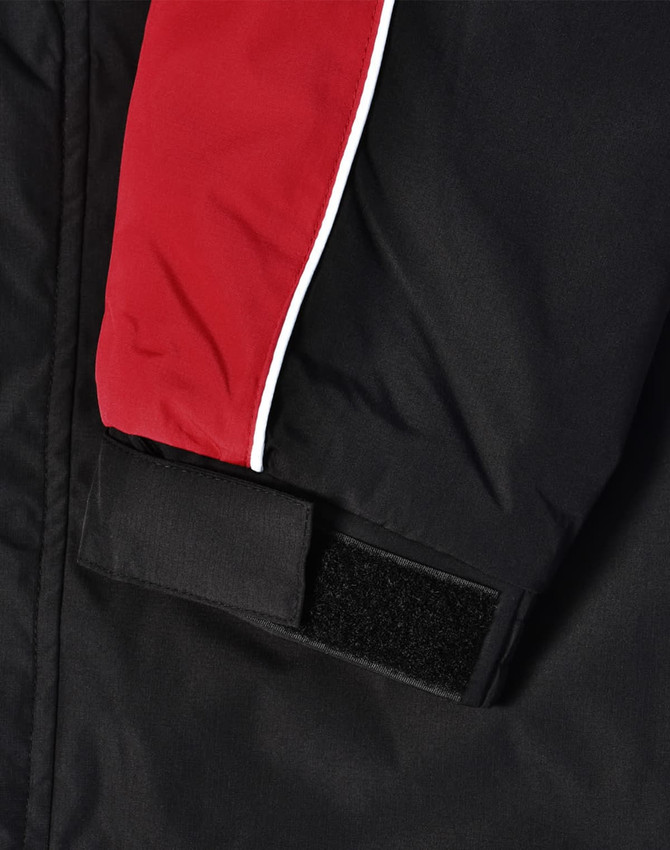 A unisex jacket featuring black fabric with red and white accents and a velcro closure on the sleeve.