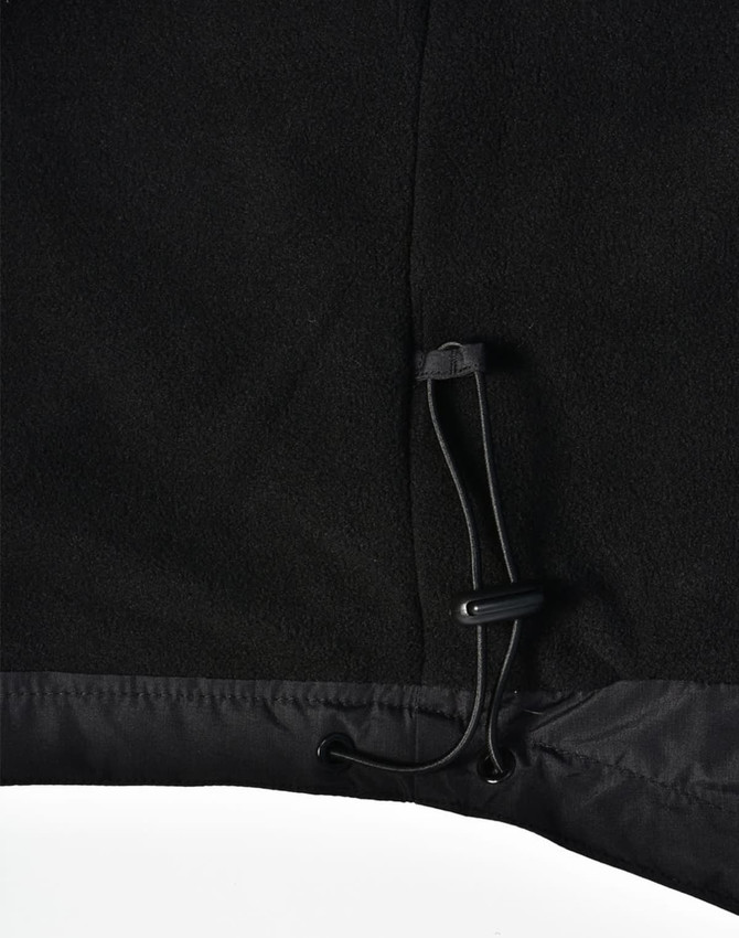 A close-up of a black unisex jacket featuring a pull cord at the hem, with a soft textured finish.