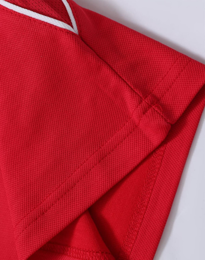 A red polo shirt with a textured fabric and white trim at the collar and sleeve edges. It has a logo.