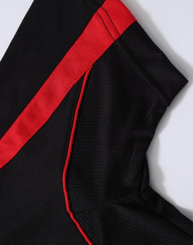 A close-up of a black polo shirt featuring red accents, highlighting the fabric texture and design details.
