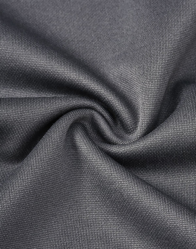 A close-up view of dark grey sustainable poly/cotton fabric, showcasing its smooth texture and stretchability.