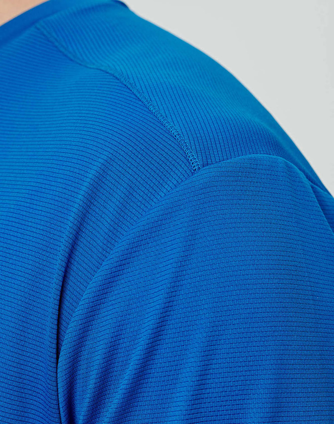 A close-up of a men's ultra lightweight performance T-shirt in vibrant blue, featuring a textured fabric.