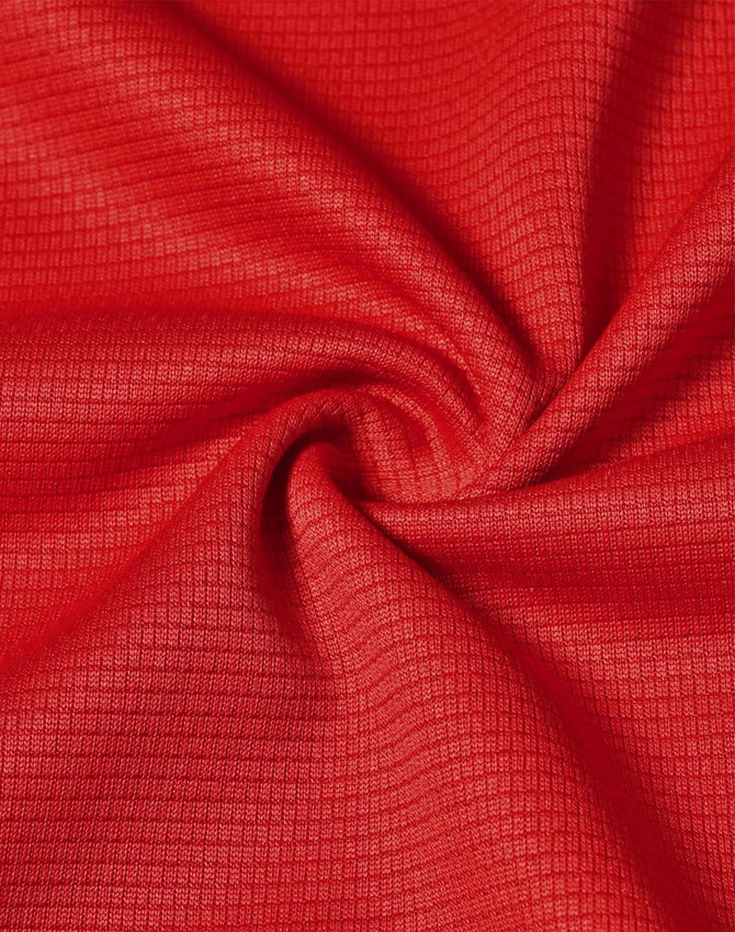 A close-up of red fabric with a textured, lightweight appearance suitable for performance wear.
