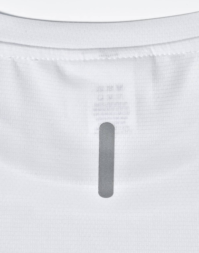 A close-up of a white men's lightweight performance T-shirt showing the neckline and tag area, with a branding label.
