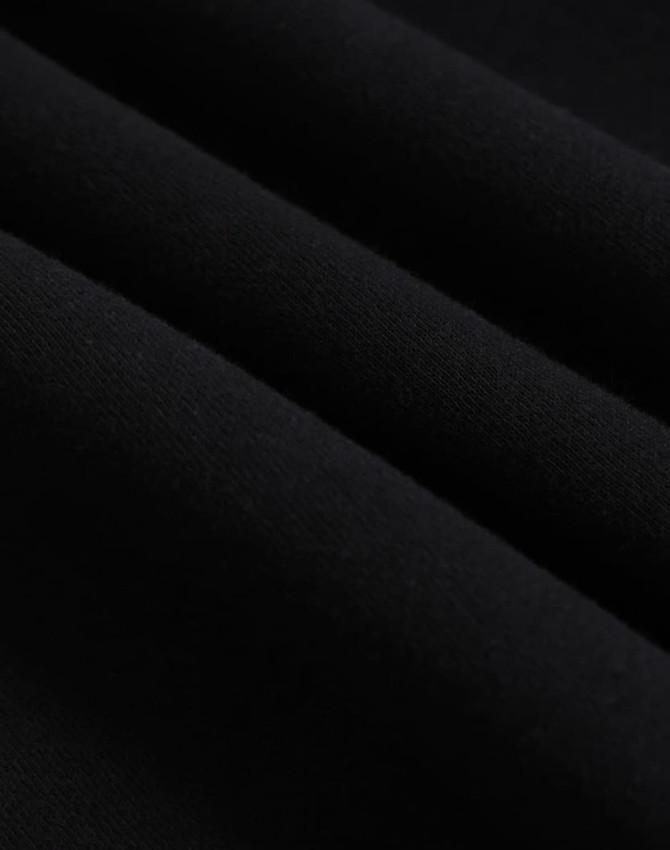 A close-up of black polar fleece fabric, showcasing its soft texture and layering. The image features a logo.