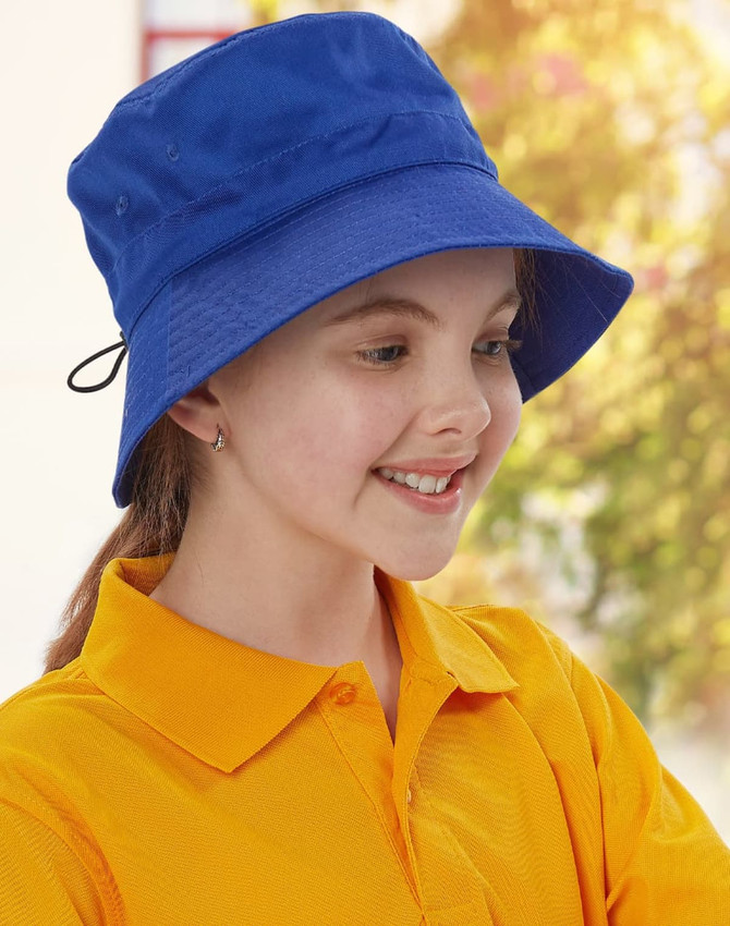 A blue bucket hat with a toggle, worn by a smiling child in a bright yellow shirt. The hat has a logo.
