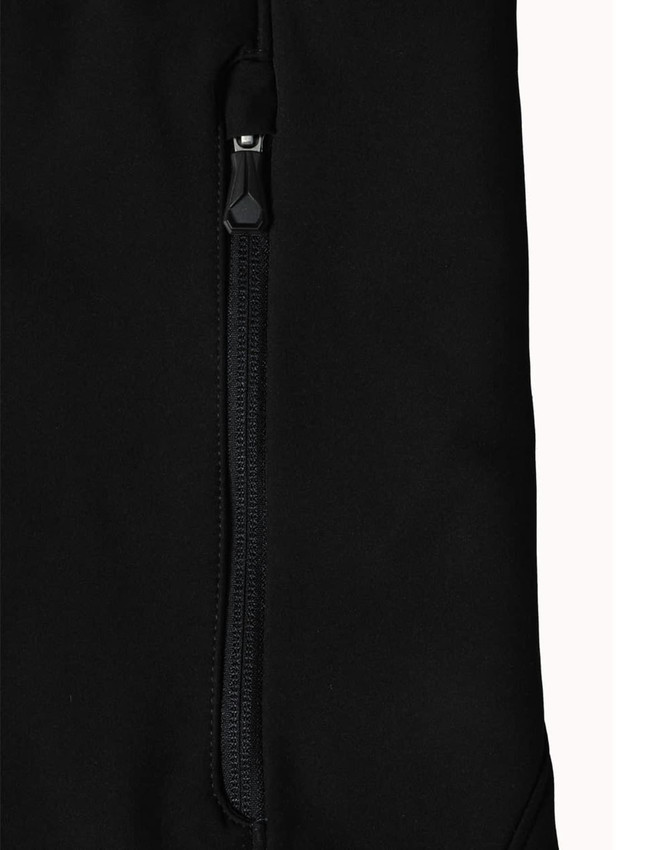 A close-up of a black softshell jacket featuring a zipped pocket and a branded logo.