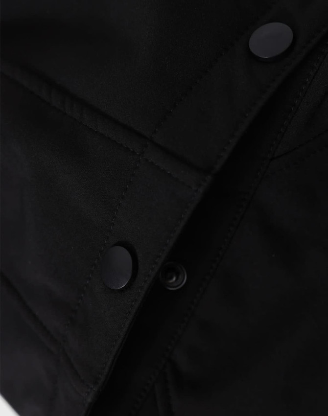 A close-up of a black men's softshell full zip hoodie, featuring snap buttons and textured fabric details.