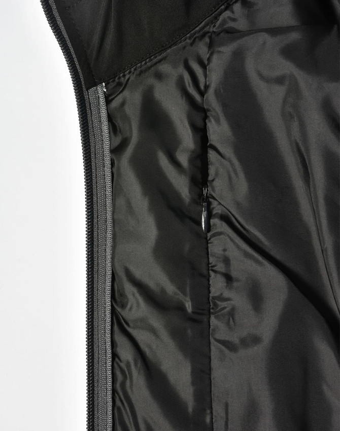 A black quilted jacket featuring a heather sleeve and a zippered pocket on the interior.