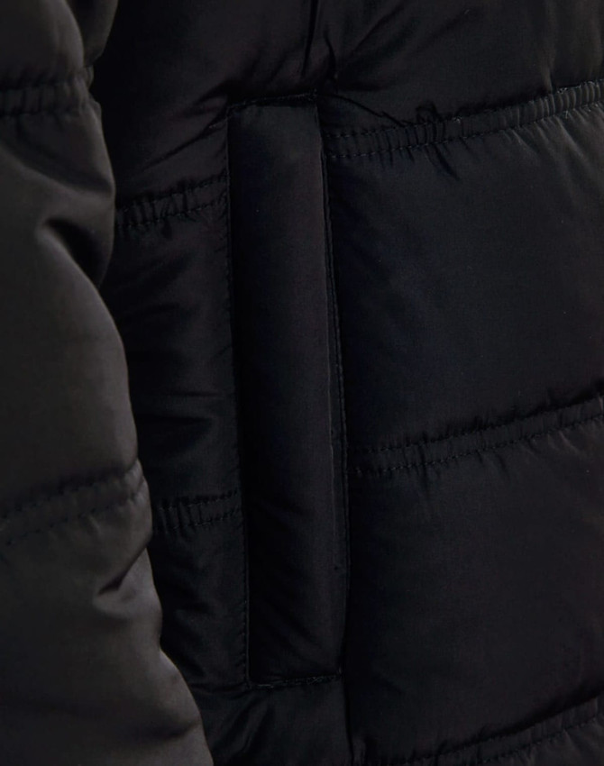 A close-up of a black heavy quilted jacket, highlighting the texture and stitching. The jacket features a brand logo.