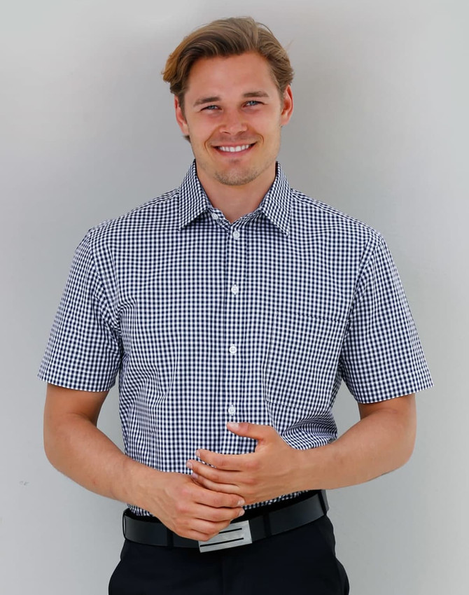 A short-sleeved men's button-up shirt in navy and white gingham check pattern, featuring a logo.