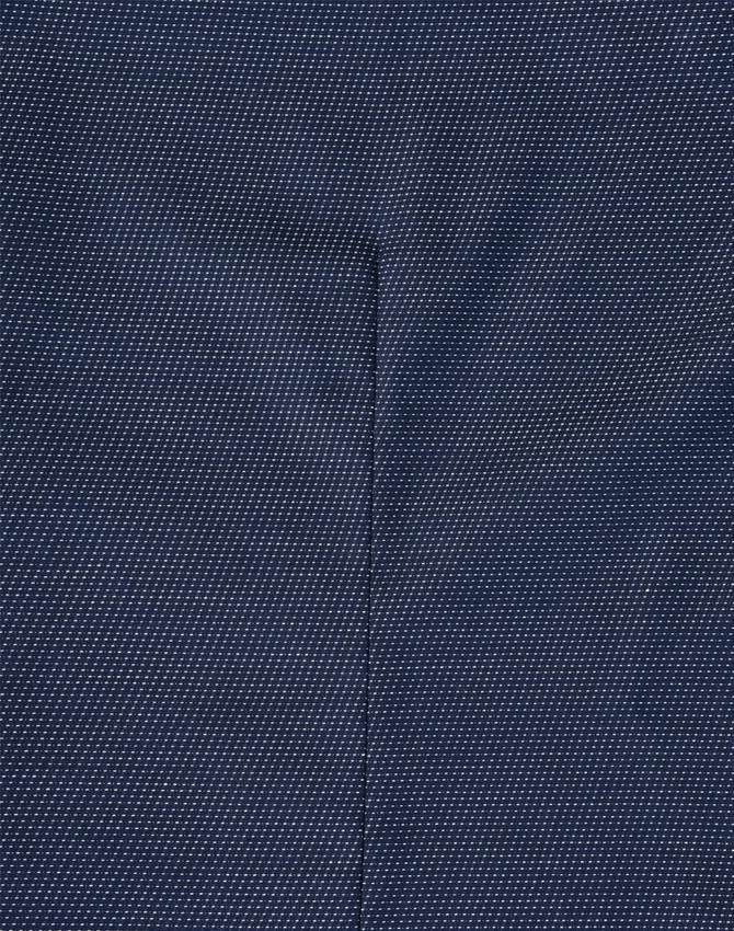 A close-up of a navy blue fabric with a pin dot pattern, showcasing the texture of the shirt.