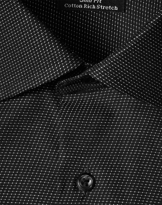 A close-up of a black pin dot stretch button-up shirt, featuring a collar and a single button.