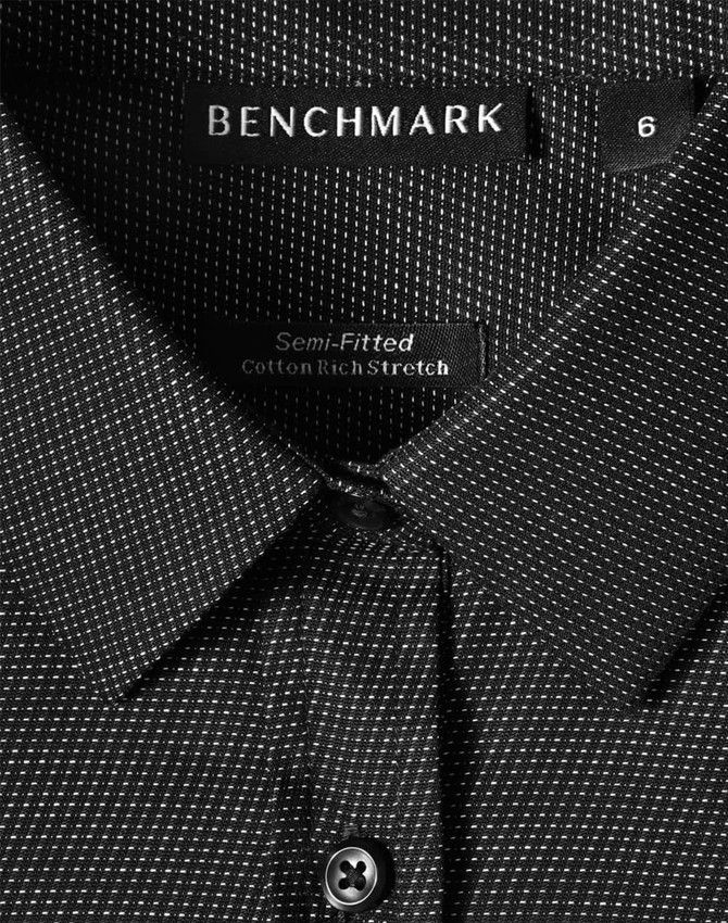 A black ladies' button-up shirt with a pin dot pattern, featuring a collar and a logo label.