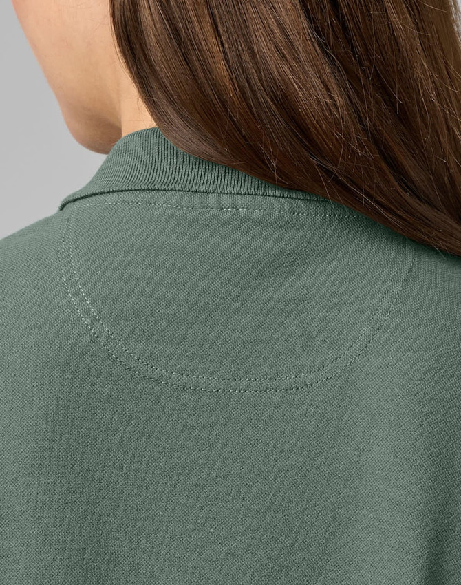 A close-up of the back of a ladies cotton stretch polo shirt in a muted green colour, featuring a collar and stitching details.