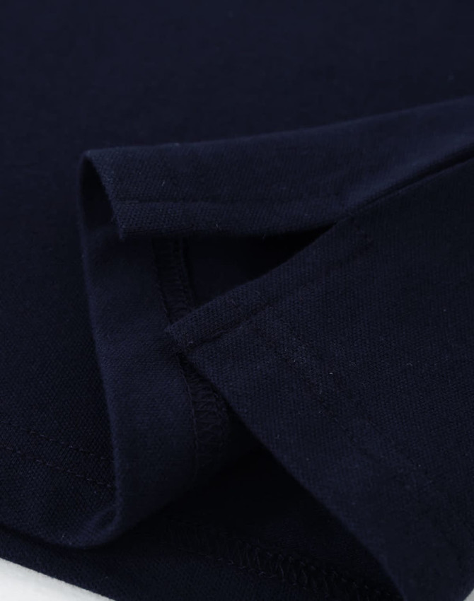 A navy ladies cotton stretch polo shirt, featuring folded sleeves and a smooth fabric texture. It has a logo.