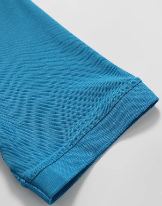 A close-up of a turquoise polo shirt sleeve, showcasing its textured fabric and cuff detail.