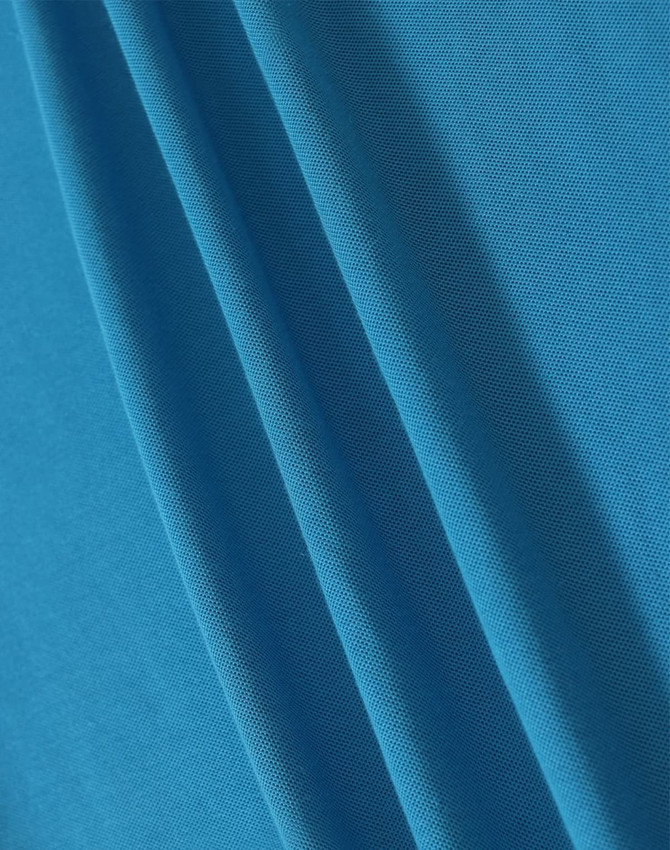 A close-up of blue fabric showcasing a textured weave, ideal for polo shirts. The fabric has a smooth appearance.