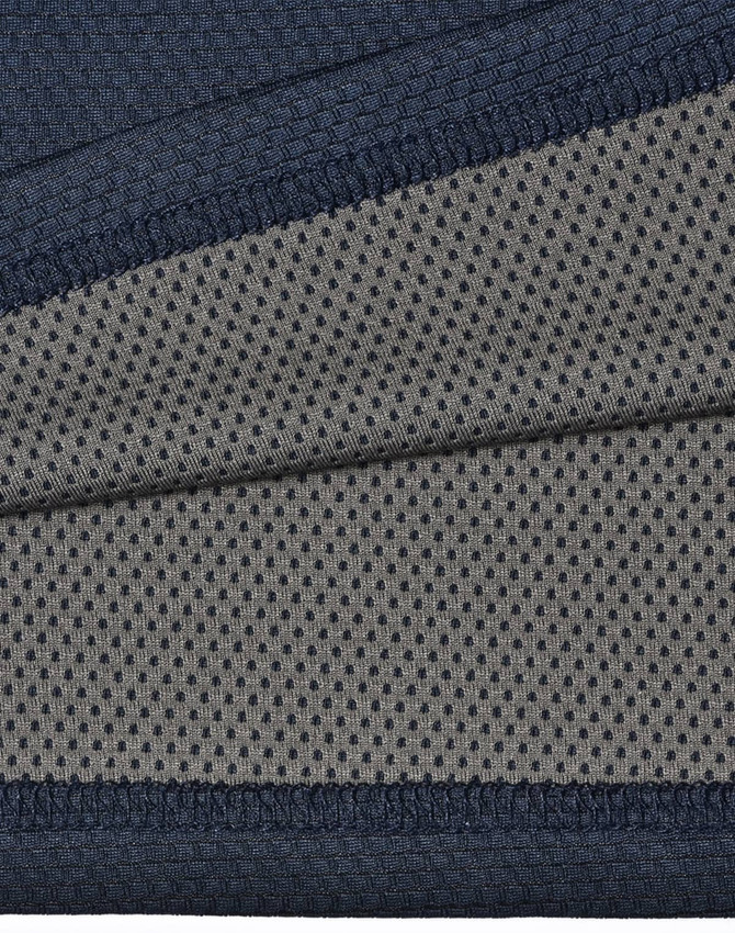 A close-up of a two-tone polo shirt featuring a navy blue top section and a grey, dotted underlay. The fabric is textured and breathable.