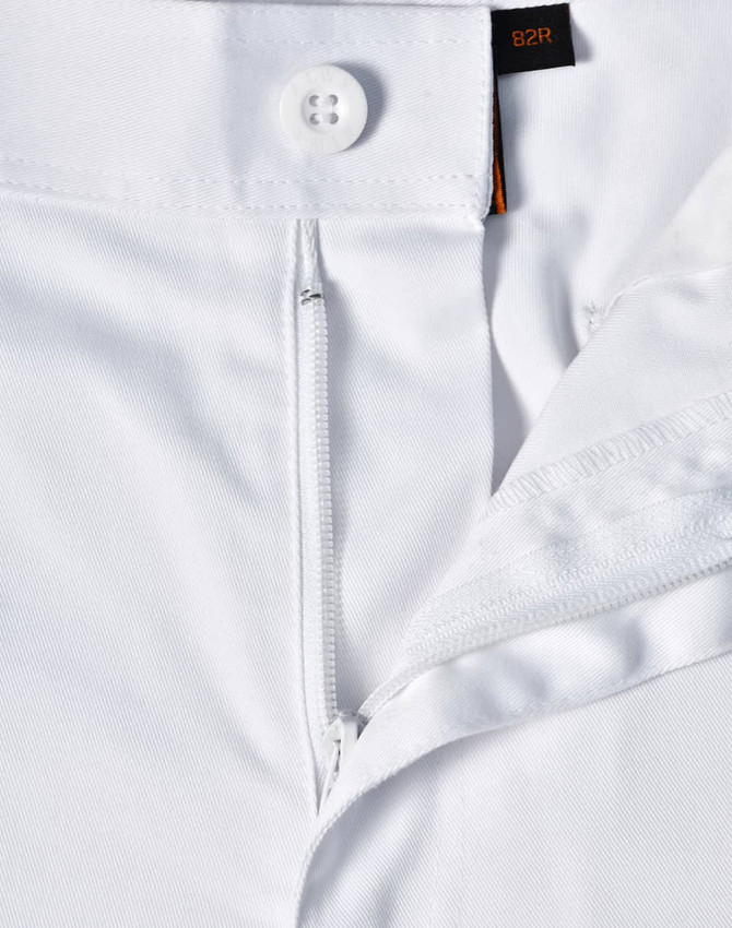 A close-up view of white unisex utility stretch cargo work pants showcasing the waistband and button detail.