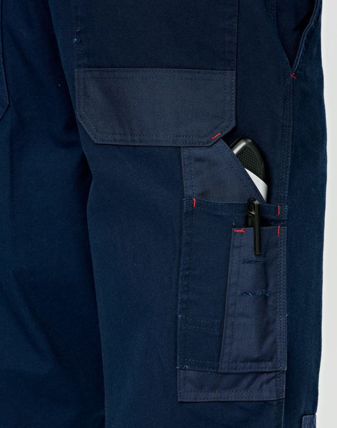 A close-up of navy blue work pants featuring multiple pockets, including a pen pocket, with visible stitching details.