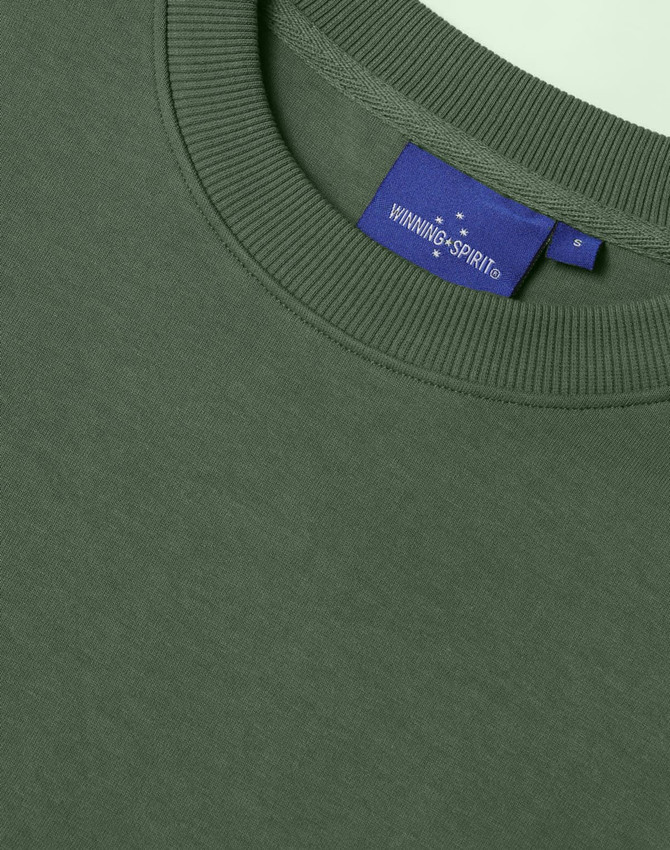 A green unisex crew neck sweater with a ribbed neckline and a small branded label inside.