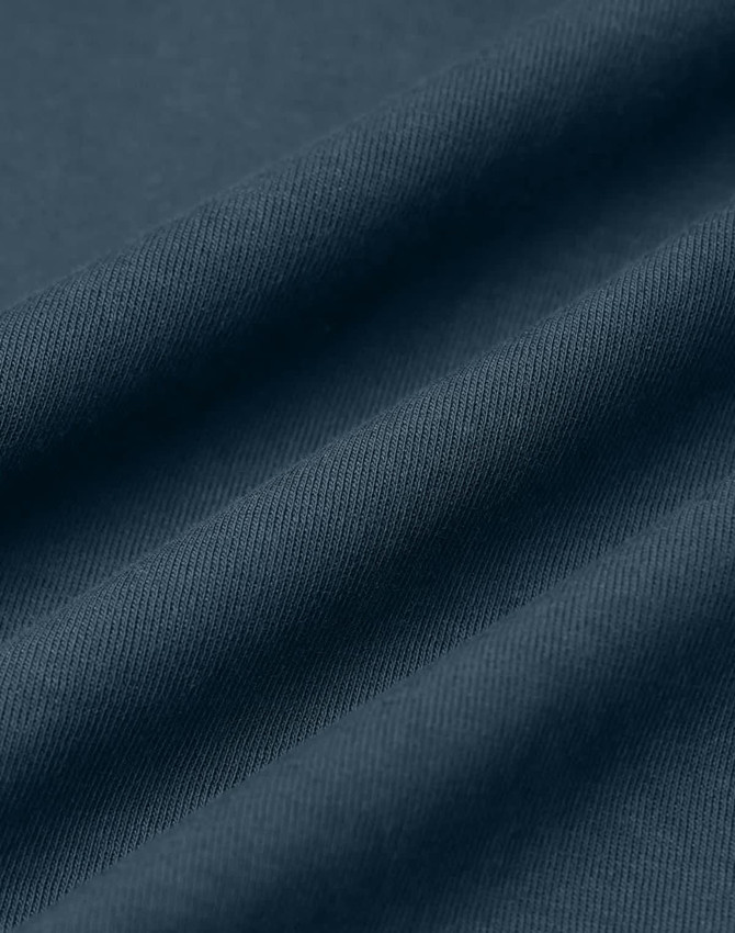 A close-up of dark blue fabric, featuring folds and a textured surface. The image has a subtle sheen.