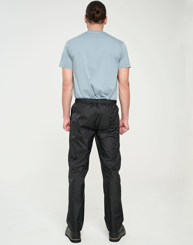 Lightweight black nylon waterproof rain pants displayed on a person from the back, wearing a grey T-shirt.