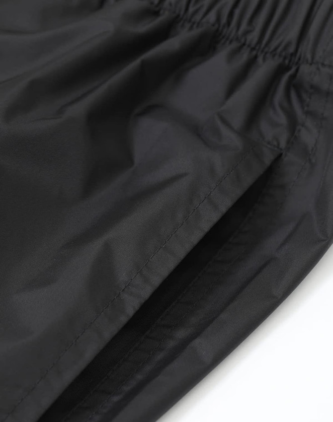 Lightweight nylon waterproof rain pants in black, featuring an elastic waistband and a smooth finish.